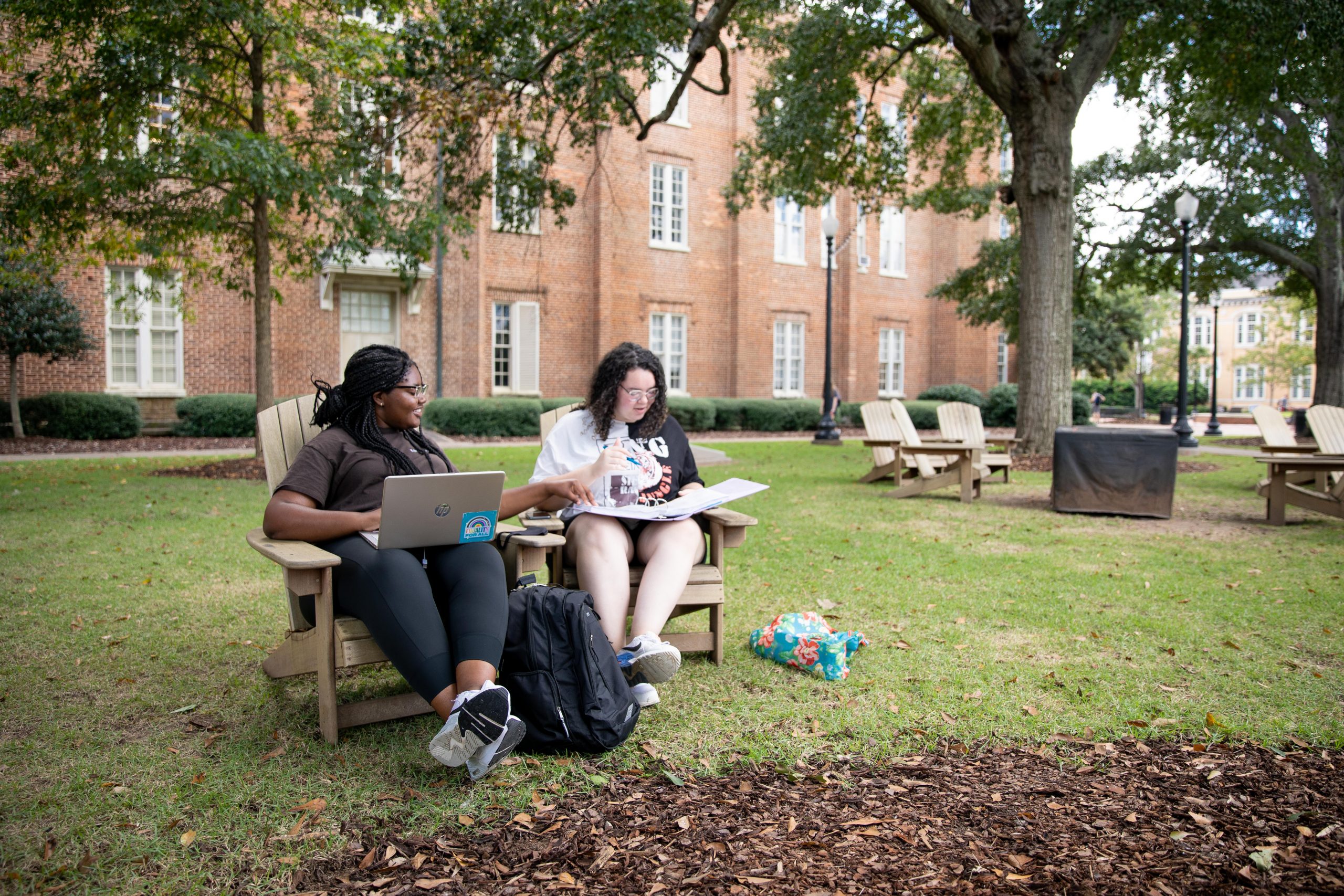 two students studying outside of woods hall